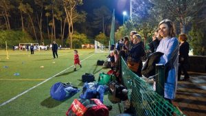 pais a assistir a um jogo de futebol dos filhos